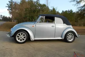 1970 Volkswagen Beetle Convertible.  Bluish silver with a dark blue cloth top. Photo