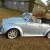 1970 Volkswagen Beetle Convertible.  Bluish silver with a dark blue cloth top.