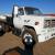 5 ton flatbed diesel truck, white single cab, bench seat, black 12' long